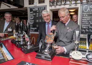 HRH pulls a pint of Greene King IPA at the White Horse, Upton